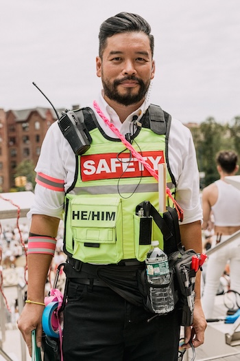 Kalaya’an Mendoza donning a hi-vis “SAFETY” vest and carrying protest safety supplies and a radio while attending the Protect Trans Youth March in Brooklyn (2021)
